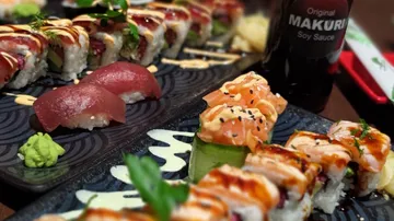 Verschiedene Sushi-Rollen mit Thunfisch-Nigiri auf Tellern.