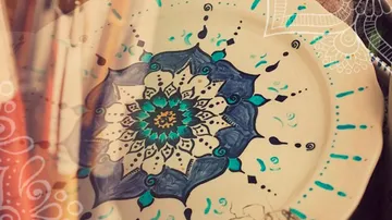 A hand-painted plate with a geometric pattern is visible.