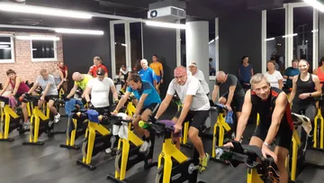 Gruppen-Fahrradkurs mit Leuten auf stationären Fahrrädern.