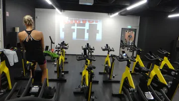 Indoor-Cycling-Raum mit gelben Fahrrädern.