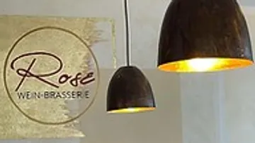 Hängelampen leuchten über einem Logo einer Brasserie.