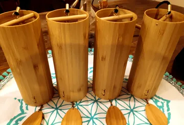 Four bamboo containers stand on a decorative plate.