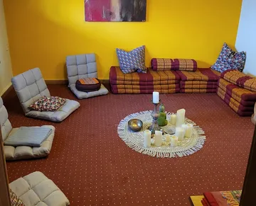 Floor cushions are arranged in a circular, relaxing atmosphere.