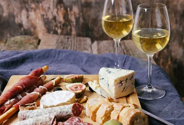 Brett voller Käse, Wurst und Wein, gemütliche Atmosphäre.
