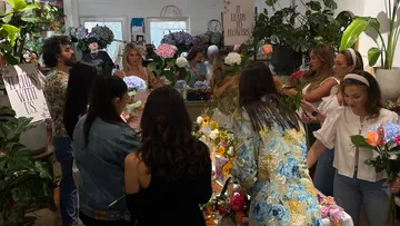 Blumenladen mit Menschen, die Blumen arrangieren und auswählen.