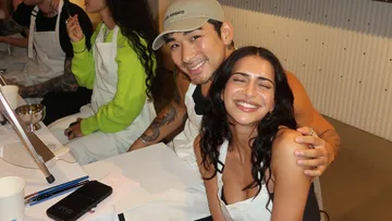 Two people sit together, smile and pose happily.