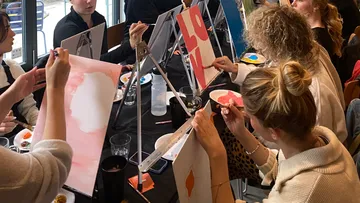 People paint on easels during a creative workshop.