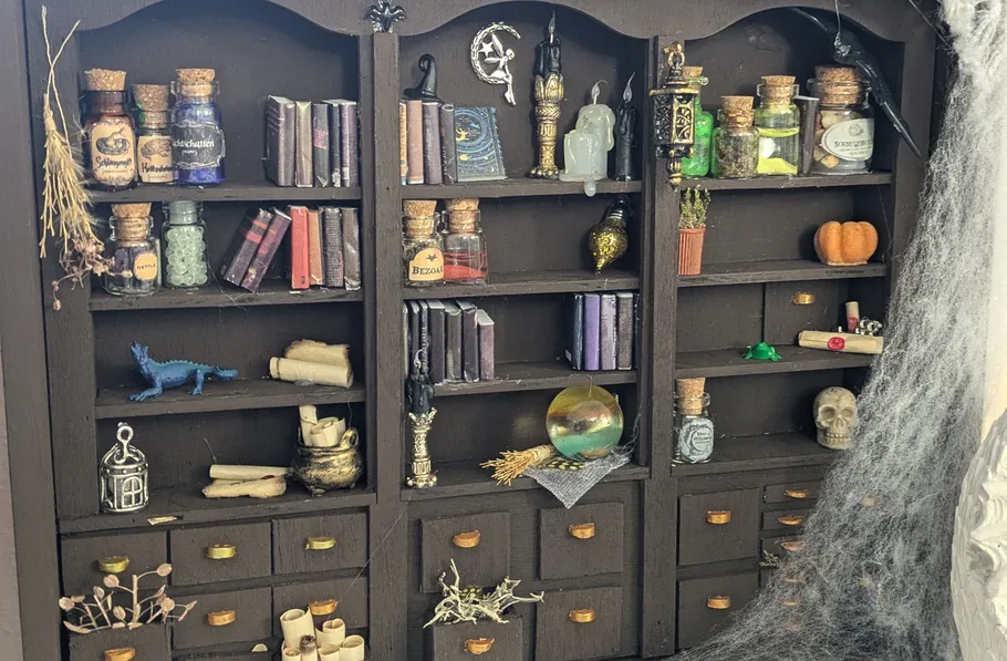 A shelf full of bottles, books, and mystical objects.