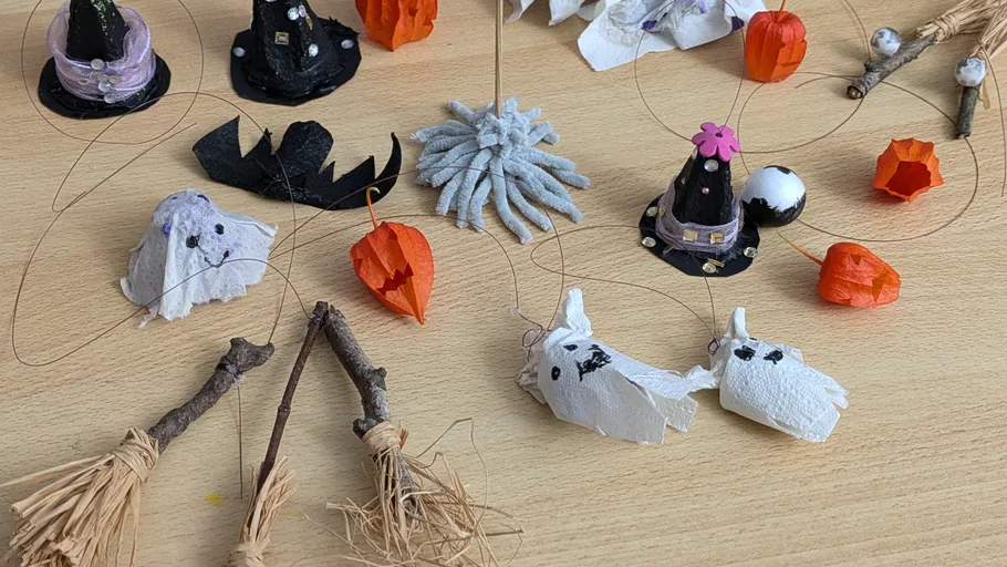 Halloween-Dekorationen zum Selbermachen auf einem Holztisch.