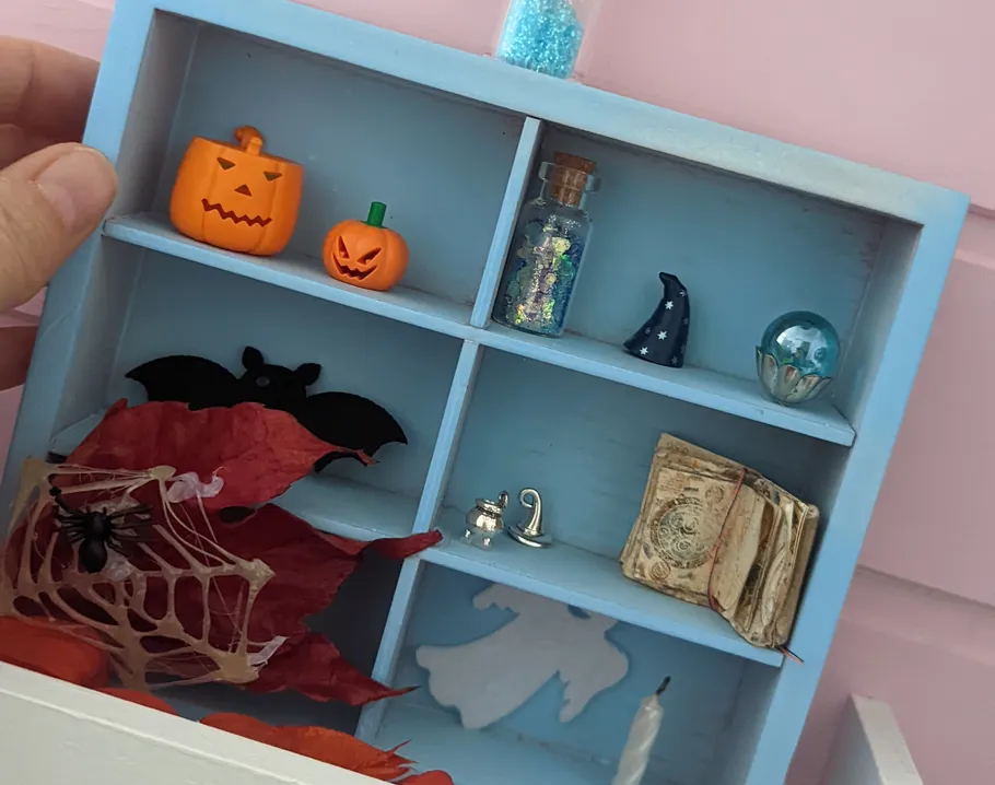 Miniaturregal im Halloween-Stil mit Dekorationen.