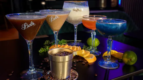 Five colorful cocktails on a table.