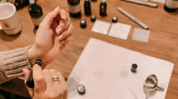 One hand applies oil to the wrist.
