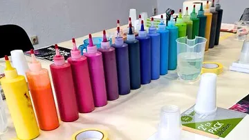 Colorful paint bottles arranged on a table.