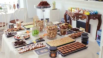 Ein Tisch voller Süßigkeiten und Snacks in hellem Raum.