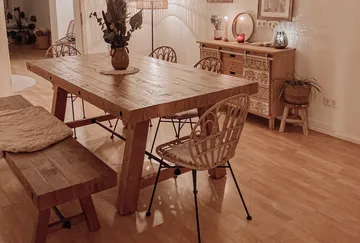 Wooden dining table with chairs in cozy room.