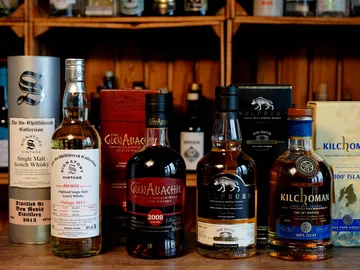 Whiskeyflaschen stehen auf einem Regal in einer Bar.
