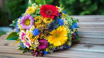 Colorful flower bouquet on wooden table.