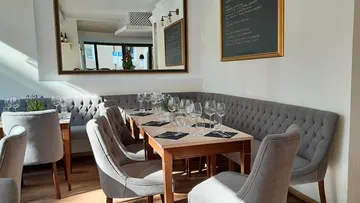 Elegante Stühle um einen gedeckten Tisch in einem Restaurant.