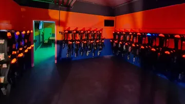 Laser weapons hang on the wall in a colorful room.