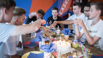 Young people eat cake and snacks at a party.