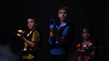 Three children with glowing toy guns are ready.