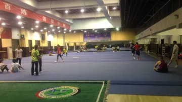 Sporthalle mit vielen Jugendlichen, die verschiedene Aktivitäten ausüben.