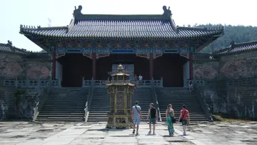 Menschen gehen zu einem historischen Tempel mit Stufen.