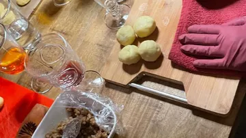 Potatoes lie on a board while someone is preparing.