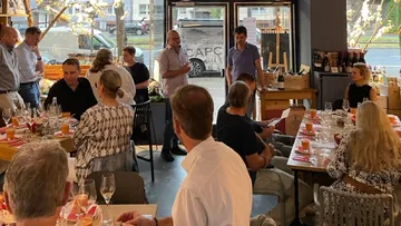 Gruppe von Leuten, die drinnen essen und reden.