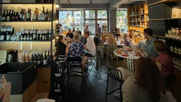 Leute, die in einer gemütlichen Weinhandlung essen.