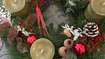 Green advent wreath with candles, pine branches and decoration