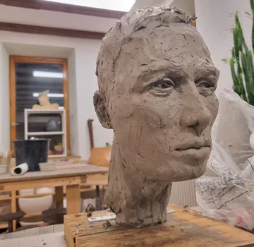 Tonkopf wird gestaltet in einem Atelier mit Werkzeugen.
