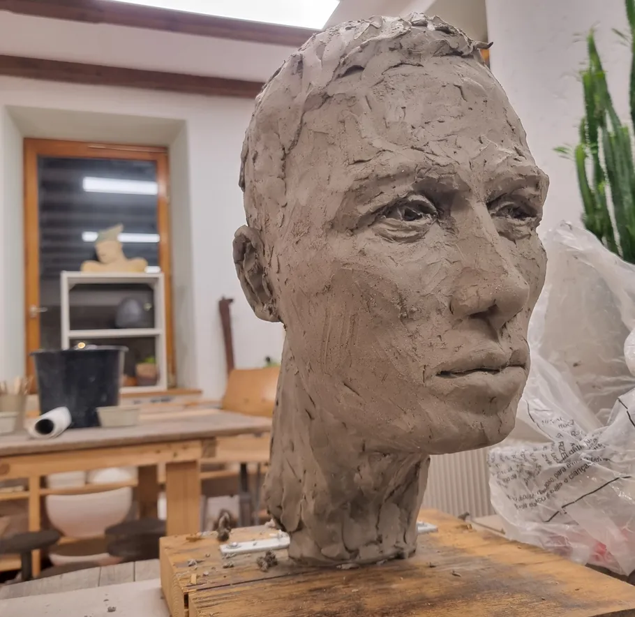 Clay head is designed in a studio with tools.