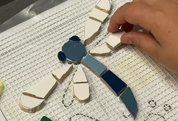 Mosaic kite rest is put together by one hand.