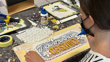 A person creates a mosaic while working.