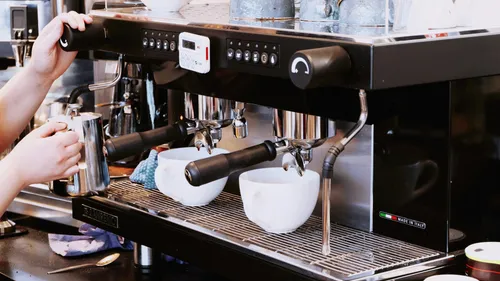 A machine prepares coffee in a coffee house environment.