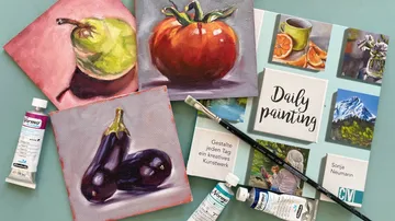 Paintings of fruit with art supplies on table.