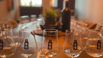 Glasses with a logo are placed on a set table.
