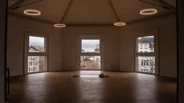Spacious room with windows and modern ceiling lights.