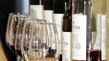 Wine bottles and glasses lined up.