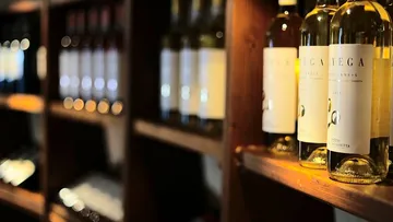 Wine bottles displayed on a wooden shelf.