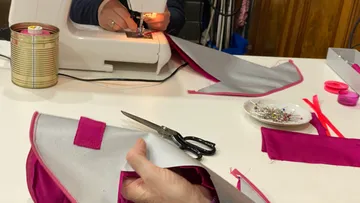 Person sewing fabric on a sewing machine.