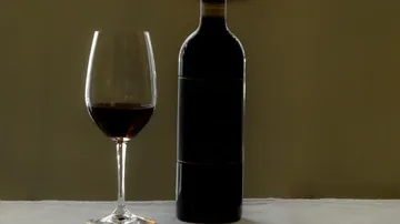 Weinflasche und Glas auf dem Tisch.