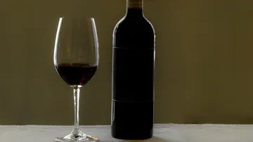 Wine bottle and glass on table.