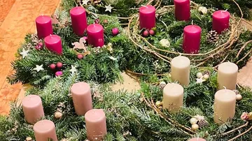 Christmas wreaths with candles on display.
