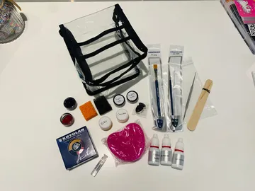 Transparente Tasche mit Schminkutensilien auf einem Tisch.