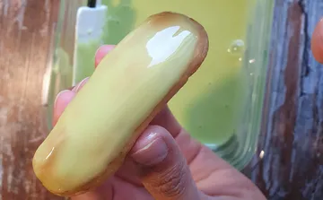 Handhaltender Eclair mit grüner Glasur.