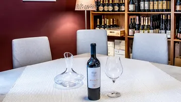 Weinflasche und Glas auf dem Tisch im Keller.