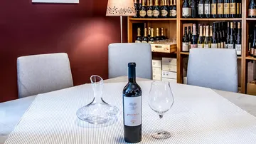 Wine bottle and glass on table in cellar.