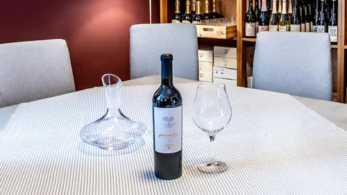 Weinflasche und Glas auf dem Tisch im Keller.